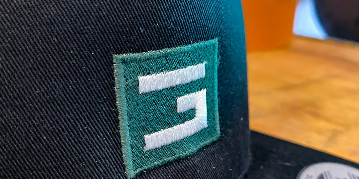 Mit grün-weißem Logo bestickte Cap